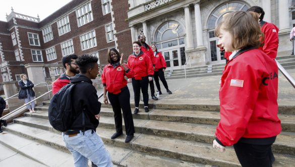 City Year AmeriCorps members create a welcome tunnel down both sides of the school's front steps