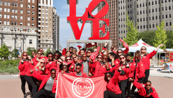 Philadelphia AmeriCorps members with flag at LOVE sign