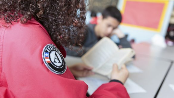 An AmeriCorps member and a student read a chapter book together.