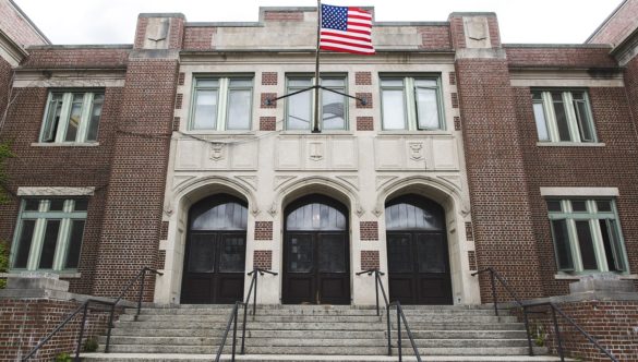 The entrance to a school with an American flag flying in the front.
