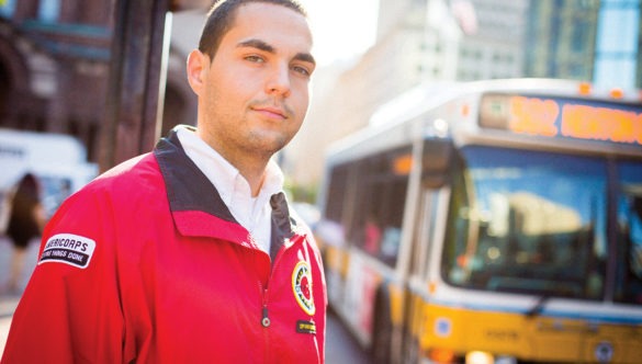 AmeriCorps member stands at a bus stop.
