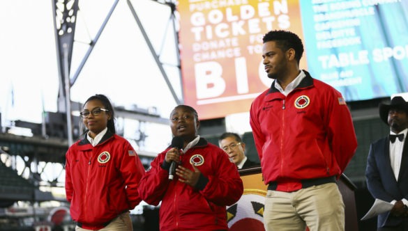 AmeriCorps members kick off a City Year event inside a large sports stadium