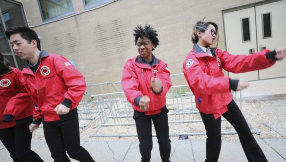 Four AmeriCorps members dance as they try to energize students for a day of learning