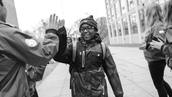a student gives an americorps member a high-five during morning power greeting