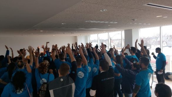 AT&T volunteers throw their hands up in a spirit break at the end of their service day