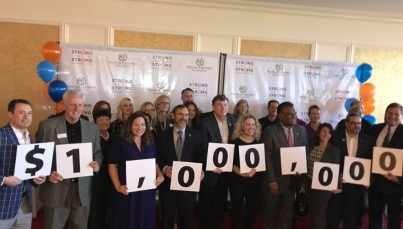 Westgate employees hold a sign that says $1,000,000 to signify this milestone
