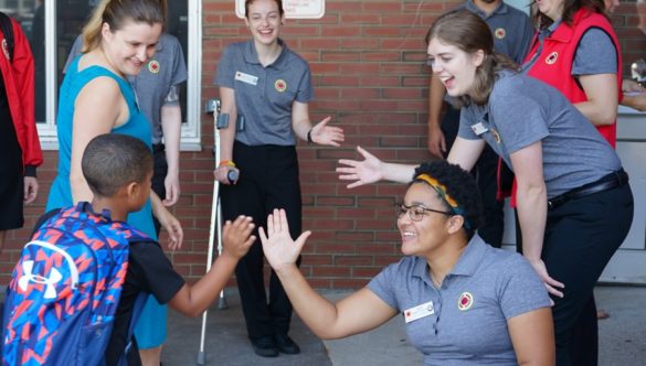 City Year corps members greet students on the first day of school