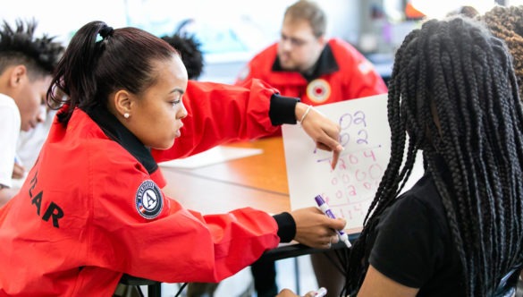 City Year AmeriCorps in school service red uniform