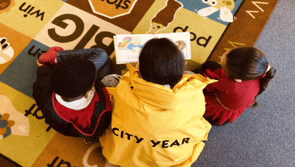 City Year in school service reading with students